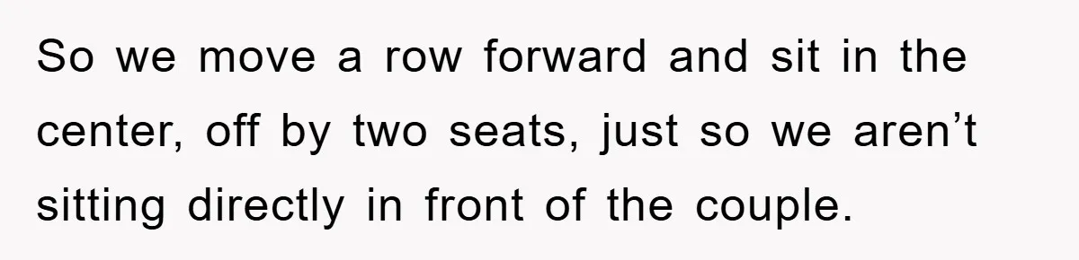 So we move a row forward and sit in the center, off by two seats, just so we aren’t sitting directly in front of the couple.
