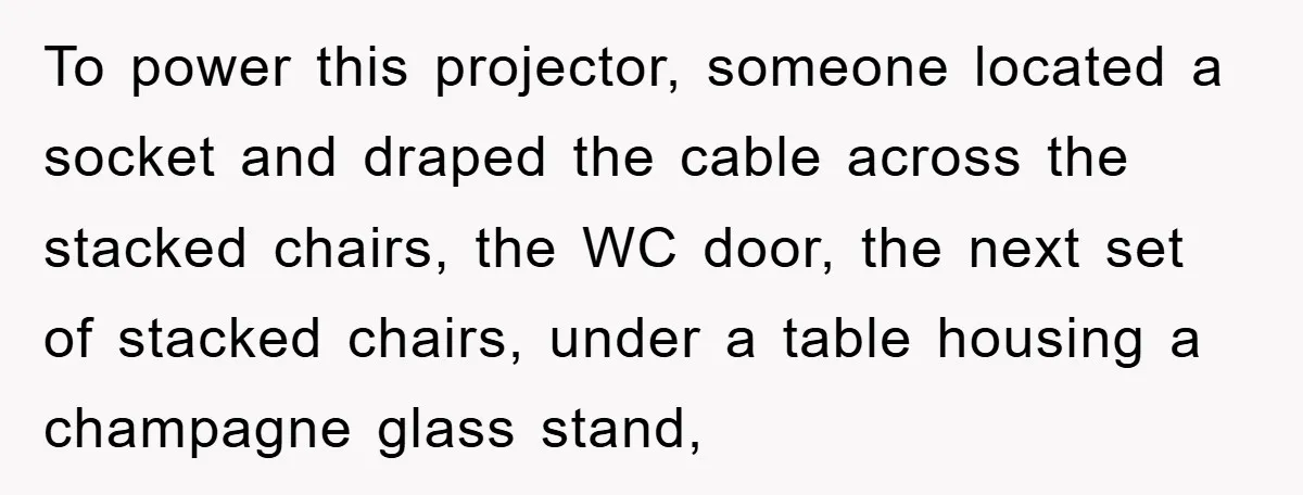 To power this projector, someone located a socket and draped the cable across the stacked chairs, the WC door, the next set of stacked chairs, under a table housing a...