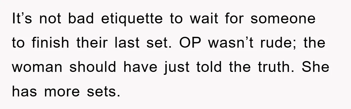 It’s not bad etiquette to wait for someone to finish their last set. OP wasn’t rude; the woman should have just told the truth. She has more sets.