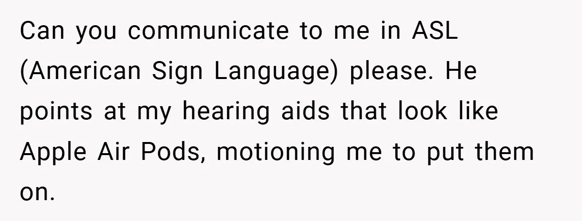 Can you communicate to me in ASL (American Sign Language) please. He points at my hearing aids that look like Apple Air Pods, motioning me to put them on.