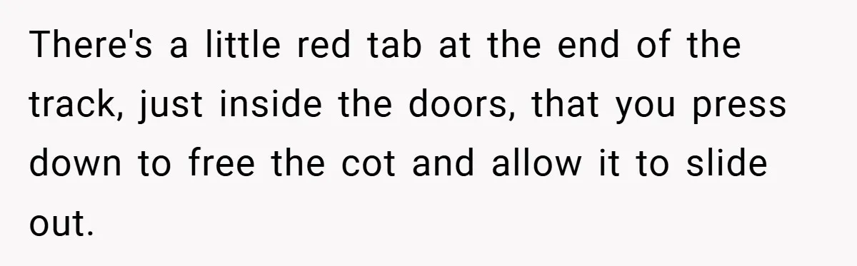There's a little red tab at the end of the track, just inside the doors, that you press down to free the cot and allow it to slide out.