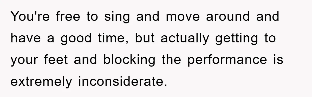 You're free to sing and move around and have a good time, but actually getting to your feet and blocking the performance is extremely inconsiderate.