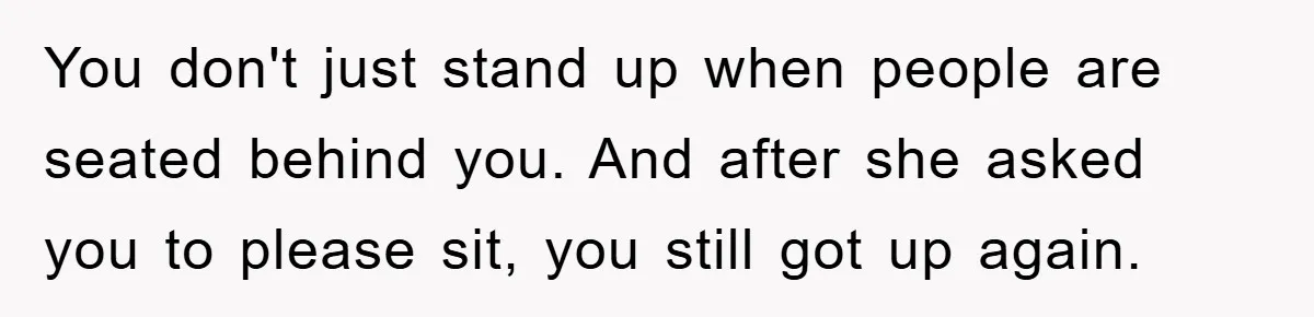 You don't just stand up when people are seated behind you. And after she asked you to please sit, you still got up again.