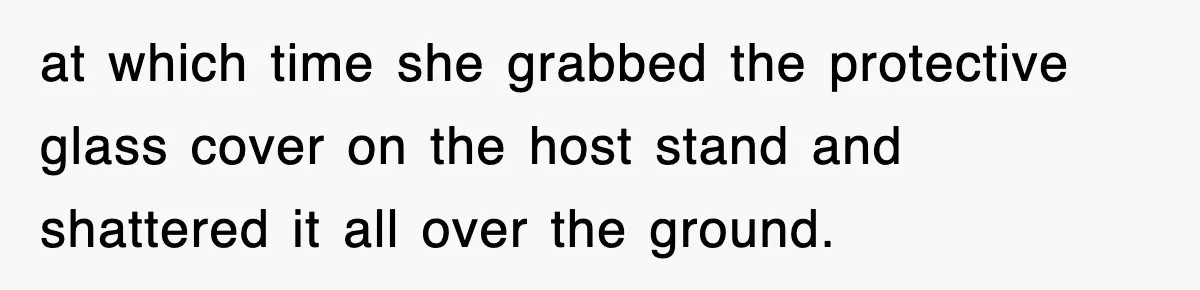 at which time she grabbed the protective glass cover on the host stand and shattered it all over the ground.