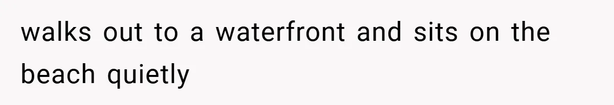 walks out to a waterfront and sits on the beach quietly