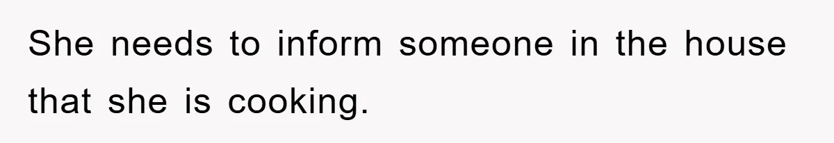 She needs to inform someone in the house that she is cooking.