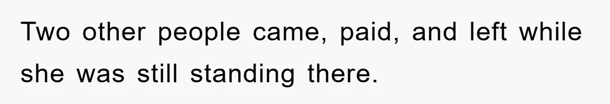 Two other people came, paid, and left while she was still standing there.