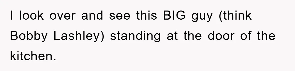 I look over and see this BIG guy (think Bobby Lashley) standing at the door of the kitchen.