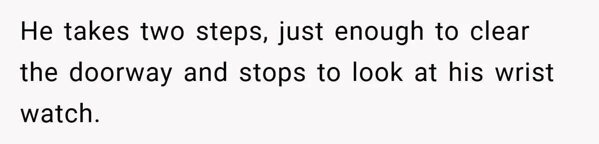 He takes two steps, just enough to clear the doorway and stops to look at his wrist watch.