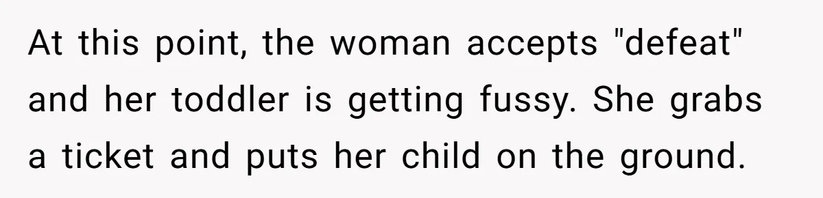 At this point, the woman accepts "defeat" and her toddler is getting fussy. She grabs a ticket and puts her child on the ground.