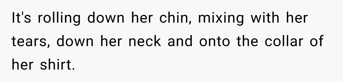 It's rolling down her chin, mixing with her tears, down her neck and onto the collar of her shirt.