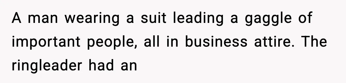 A man wearing a suit leading a gaggle of important people, all in business attire. The ringleader had an