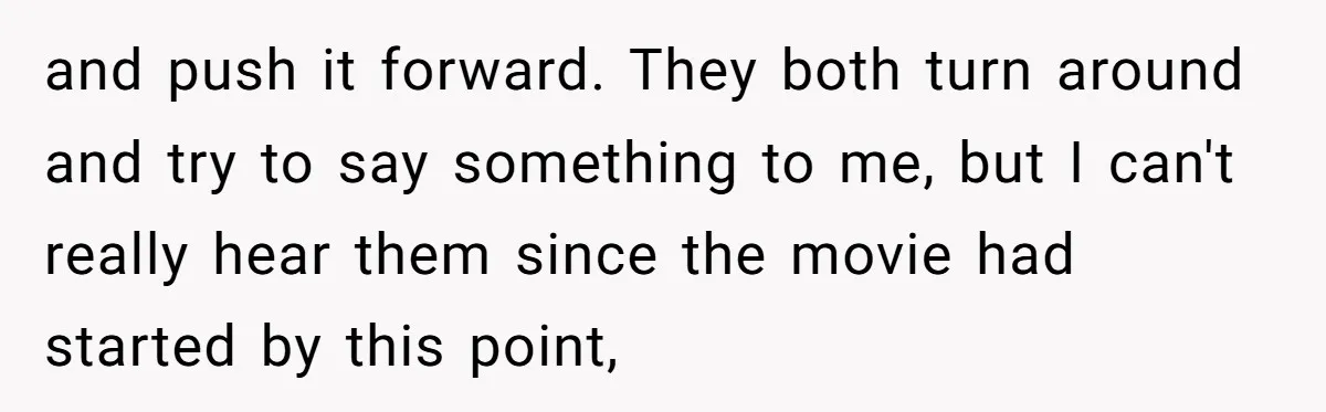 and push it forward. They both turn around and try to say something to me, but I can't really hear them since the movie had started by this point,