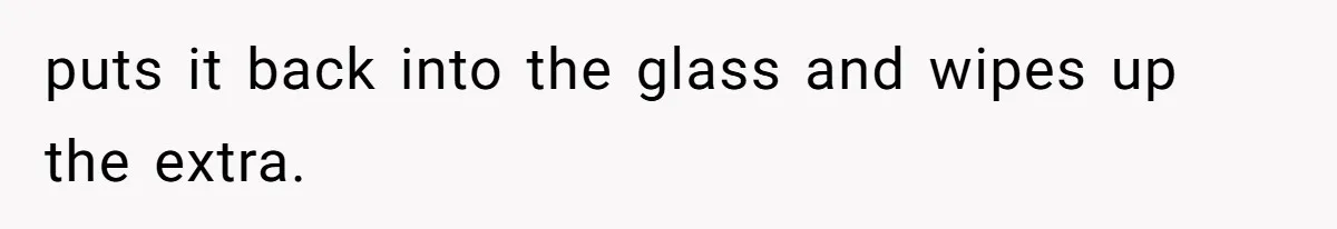 puts it back into the glass and wipes up the extra.