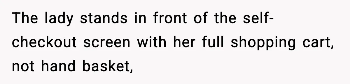 The lady stands in front of the self-checkout screen with her full shopping cart, not hand basket,
