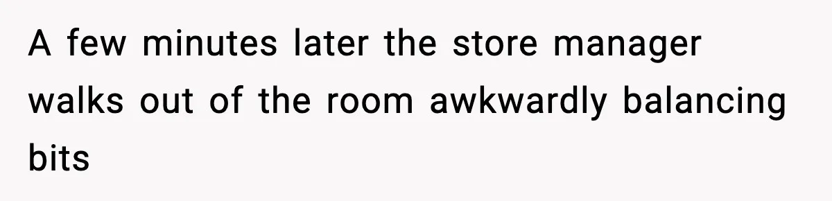 A few minutes later the store manager walks out of the room awkwardly balancing bits