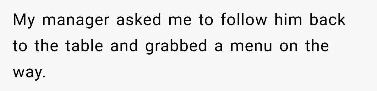 My manager asked me to follow him back to the table and grabbed a menu on the way.