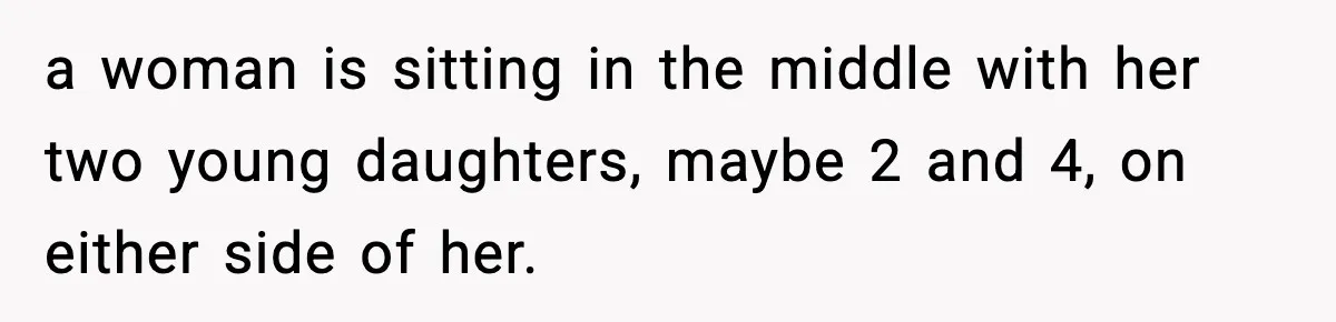 Traveler Refuses To Give Up Empty Row, Exhausted Mom Calls Her A ‘B**ch’ On Landing a woman is sitting in the middle with her two young daughters, maybe 2 and 4, on either side of her.