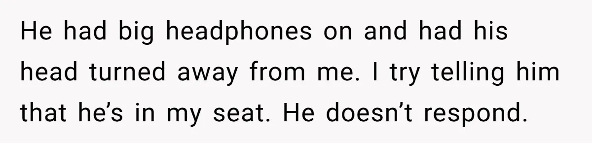 He had big headphones on and had his head turned away from me. I try telling him that he’s in my seat. He doesn’t respond.