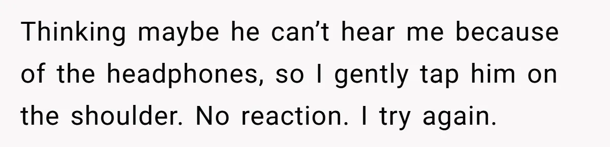Thinking maybe he can’t hear me because of the headphones, so I gently tap him on the shoulder. No reaction. I try again.