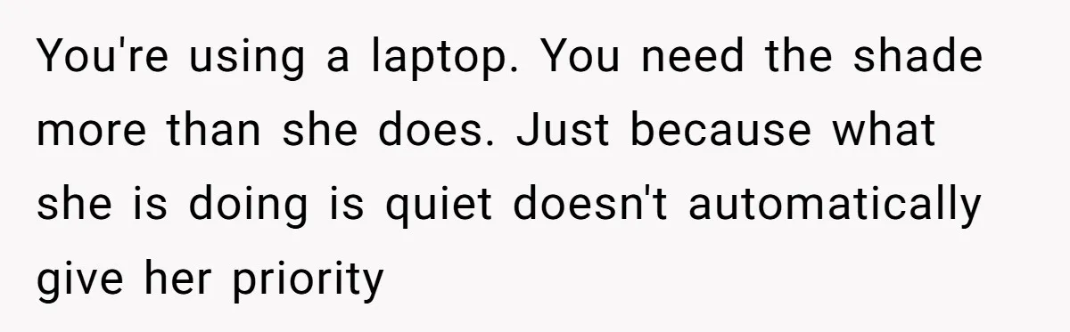 You're using a laptop. You need the shade more than she does. Just because what she is doing is quiet doesn't automatically give her priority