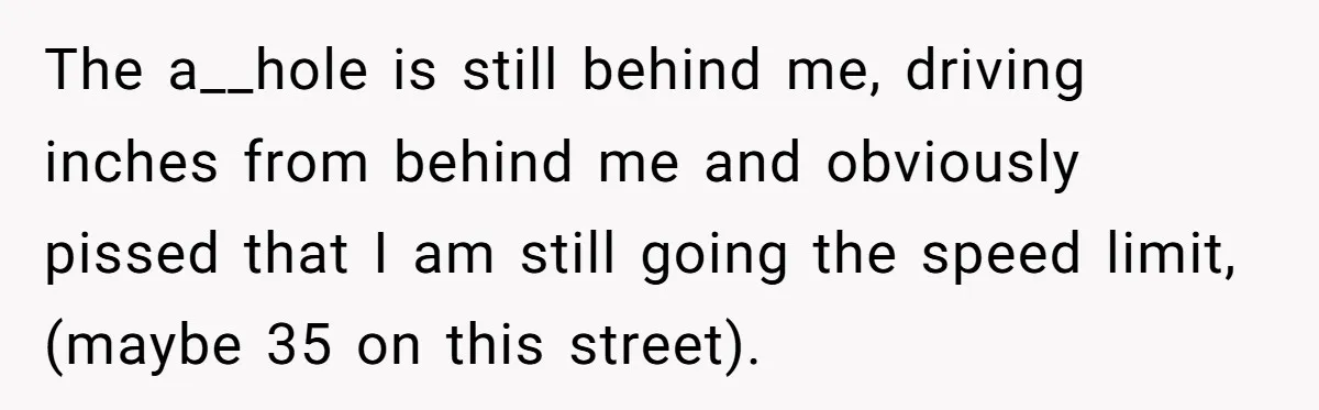 The a__hole is still behind me, driving inches from behind me and obviously pissed that I am still going the speed limit, (maybe 35 on this street).