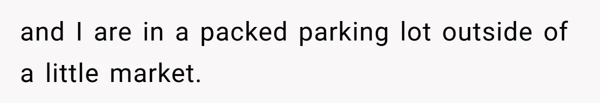 and I are in a packed parking lot outside of a little market.