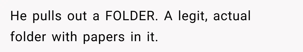 He pulls out a FOLDER. A legit, actual folder with papers in it.