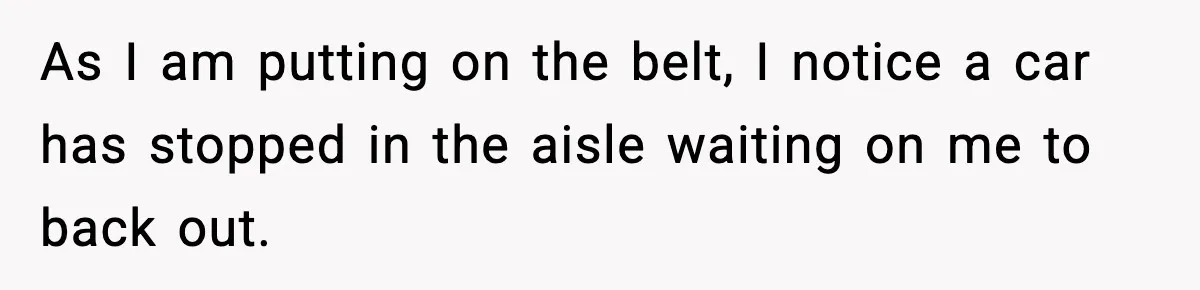 As I am putting on the belt, I notice a car has stopped in the aisle waiting on me to back out.