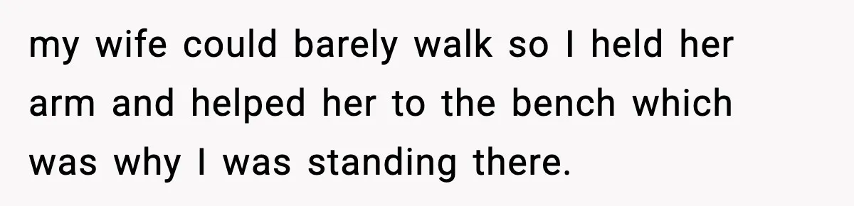 my wife could barely walk so I held her arm and helped her to the bench which was why I was standing there.