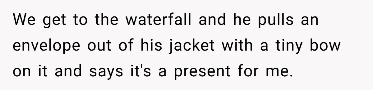 We get to the waterfall and he pulls an envelope out of his jacket with a tiny bow on it and says it's a present for me.