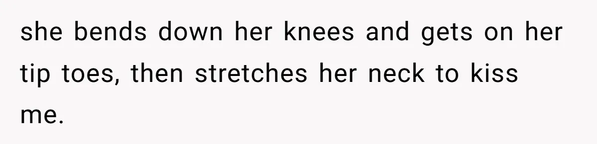 she bends down her knees and gets on her tip toes, then stretches her neck to kiss me.