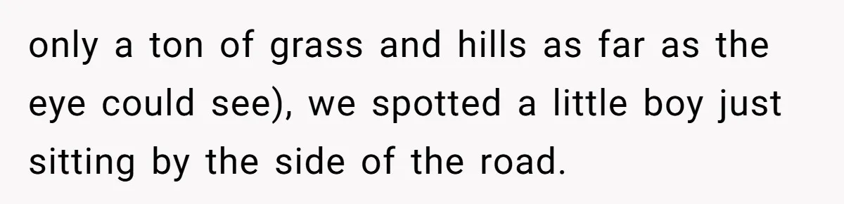 only a ton of grass and hills as far as the eye could see), we spotted a little boy just sitting by the side of the road.