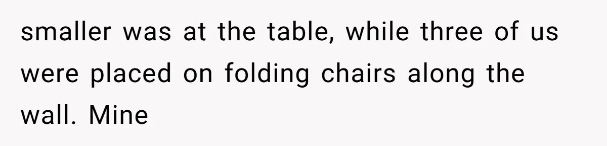 smaller was at the table, while three of us were placed on folding chairs along the wall. Mine