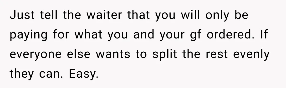 Just tell the waiter that you will only be paying for what you and your gf ordered. If everyone else wants to split the rest evenly they can. Easy.