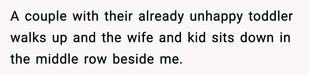 A couple with their already unhappy toddler walks up and the wife and kid sits down in the middle row beside me.