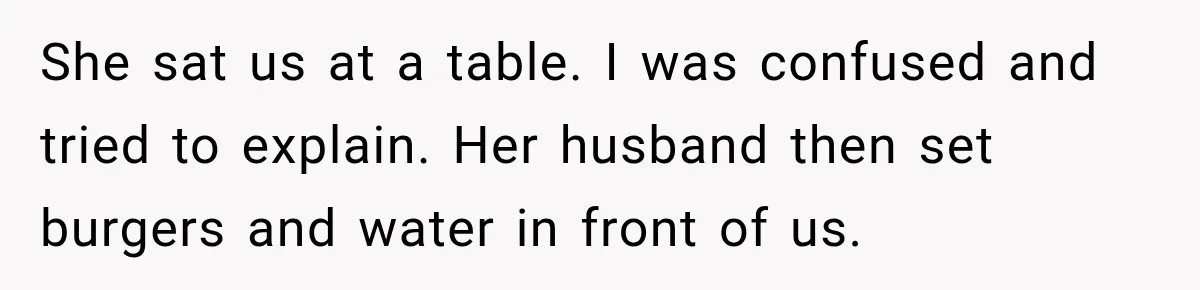 She sat us at a table. I was confused and tried to explain. Her husband then set burgers and water in front of us.