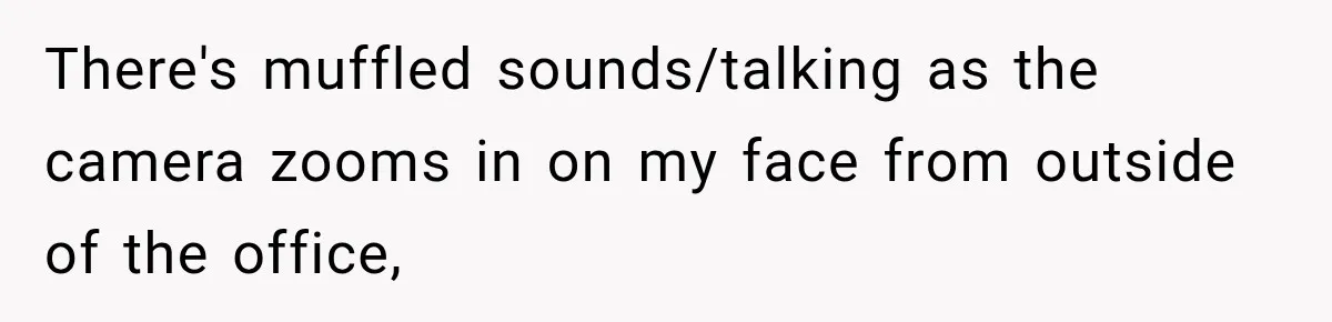 There's muffled sounds/talking as the camera zooms in on my face from outside of the office,