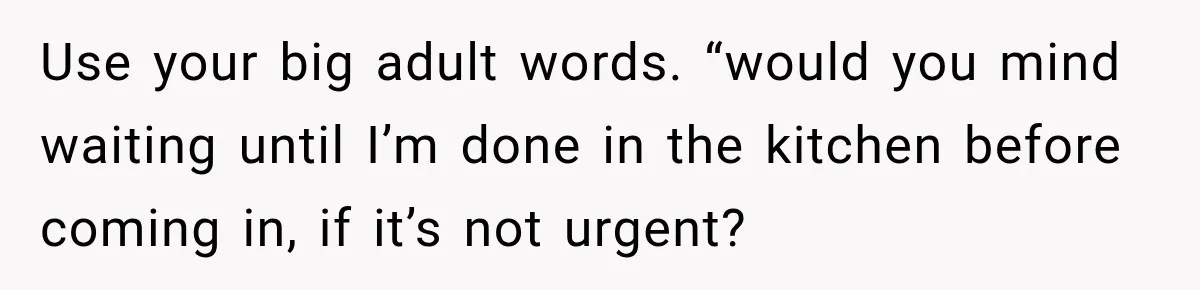 Use your big adult words. “would you mind waiting until I’m done in the kitchen before coming in, if it’s not urgent?