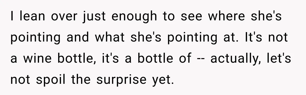 I lean over just enough to see where she's pointing and what she's pointing at. It's not a wine bottle, it's a bottle of -- actually, let's not spoil the...