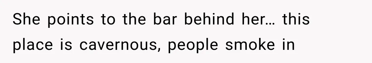 She points to the bar behind her… this place is cavernous, people smoke in