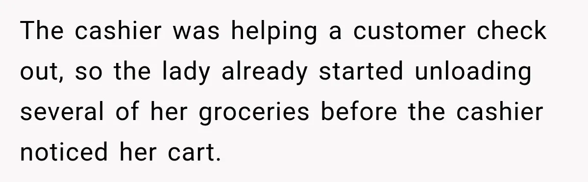 The cashier was helping a customer check out, so the lady already started unloading several of her groceries before the cashier noticed her cart.