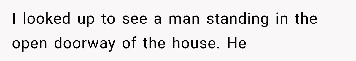 I looked up to see a man standing in the open doorway of the house. He