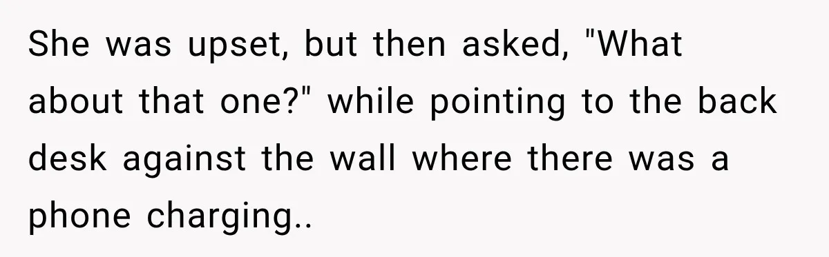 She was upset, but then asked, "What about that one?" while pointing to the back desk against the wall where there was a phone charging..